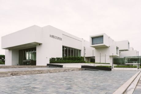 臺北市立美術館白色量體外觀與前方廣場，外牆有館名字樣。