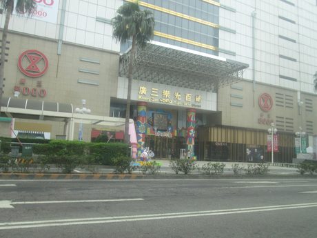 廣三SOGO百貨大門外觀，入口上方寫著「廣三崇光百貨」，前方是棕櫚樹和臺灣大道。