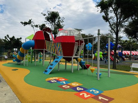 八德公園的荔枝造型與毛毛蟲主題遊具，有管狀滑梯與地面跳格子彩繪。