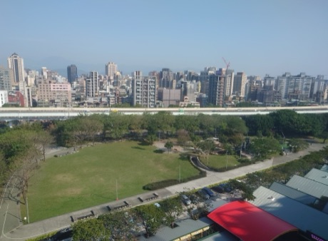從高處俯瞰中央藝文公園草地、樹林與市民大道高架道路