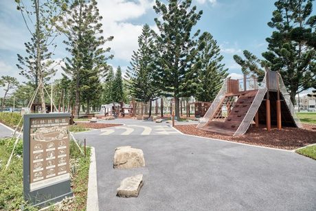 綠杉林公園的山訓主題遊戲區，高大的南洋杉林間有木造攀爬坡和障礙設施，前方是解說牌。